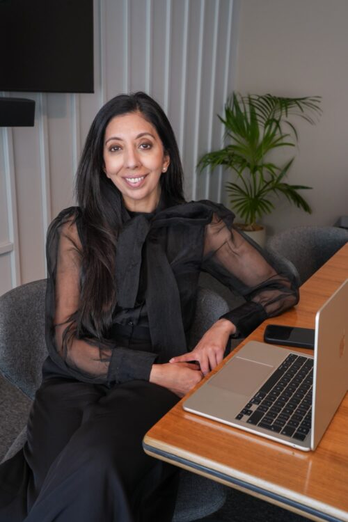 Citrus Connect founder Leena Parmar sitting at a desk with a laptop, presenting the company manifesto.