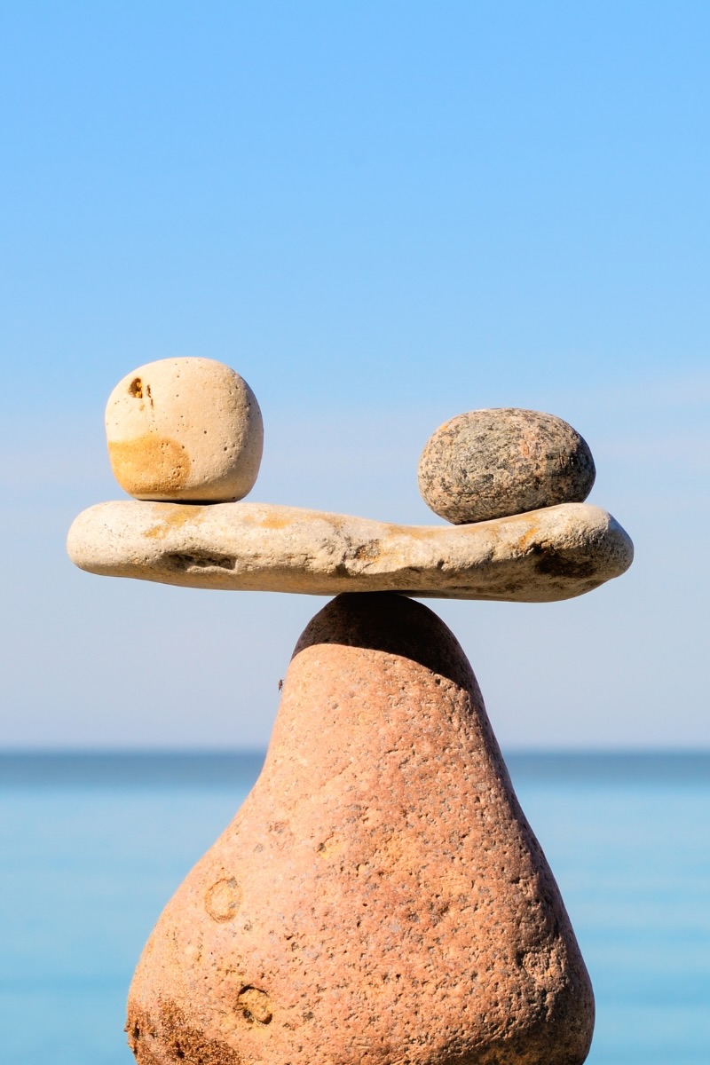 Balanced stones stacked against a blue ocean background, illustrating balanced concessions in sales negotiations.