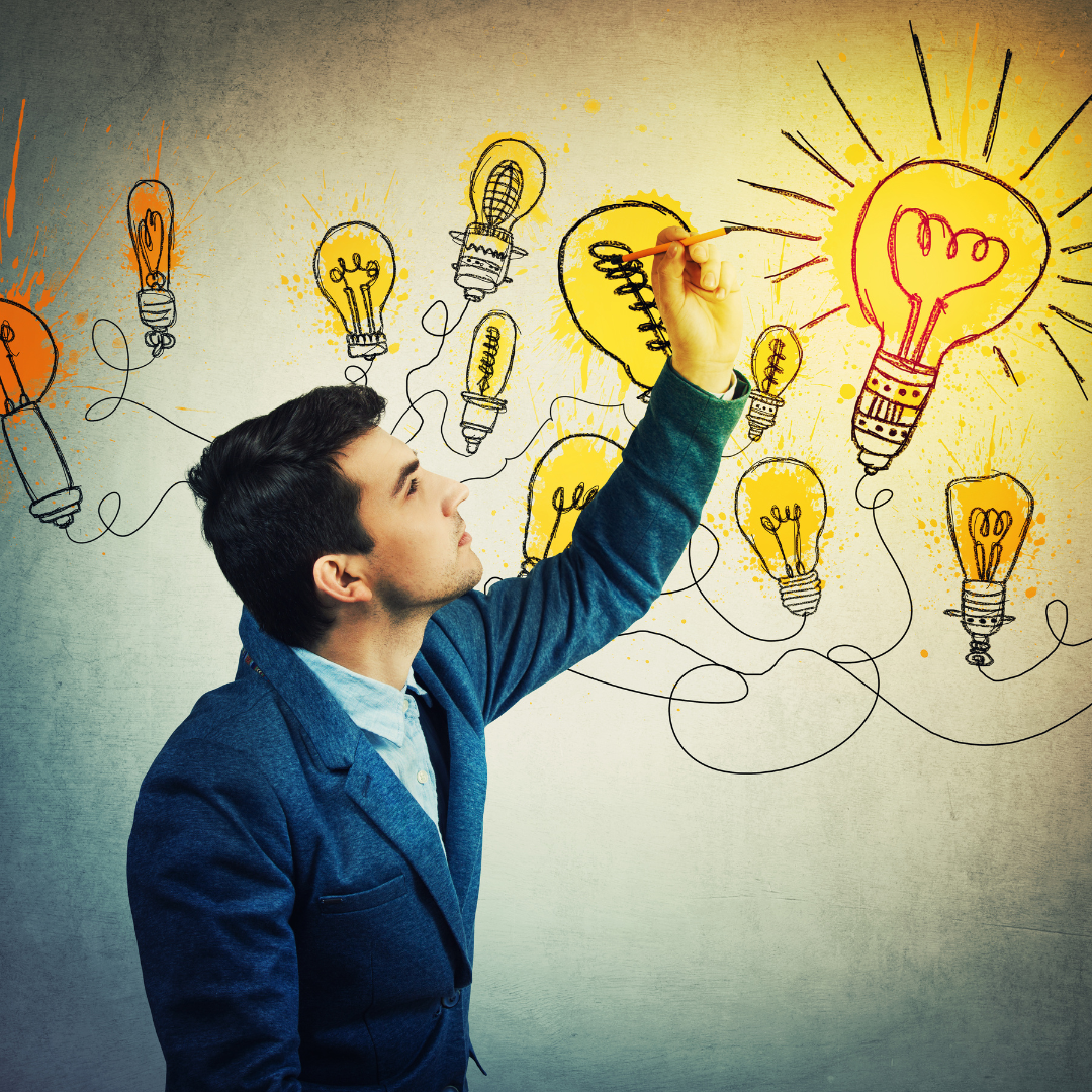 A man drawing lightbulbs on the wall