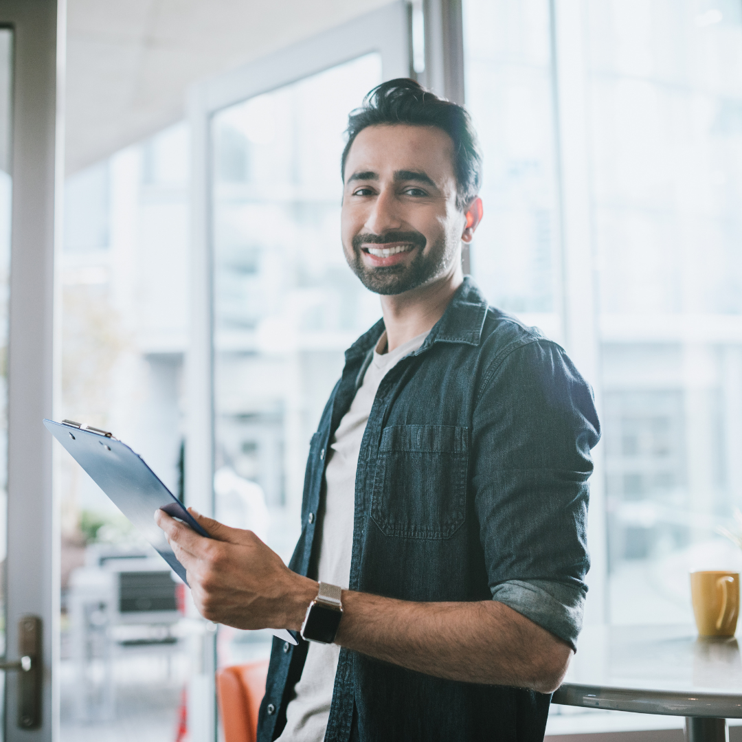 Sales professional holding a clipboard in a bright office